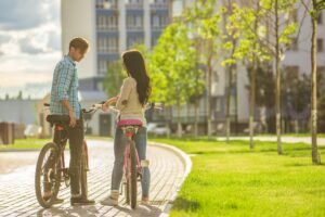 The man and woman stand with a bicycles in a residential complex