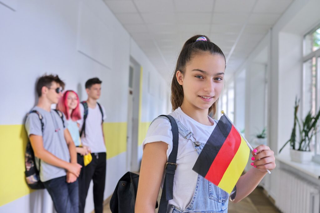 Student teenager girl with the flag of Germany inside school, school