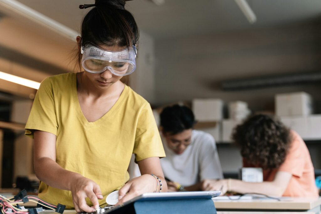 Asian Student Girl with protective goggles learning technology, robotics and electronics