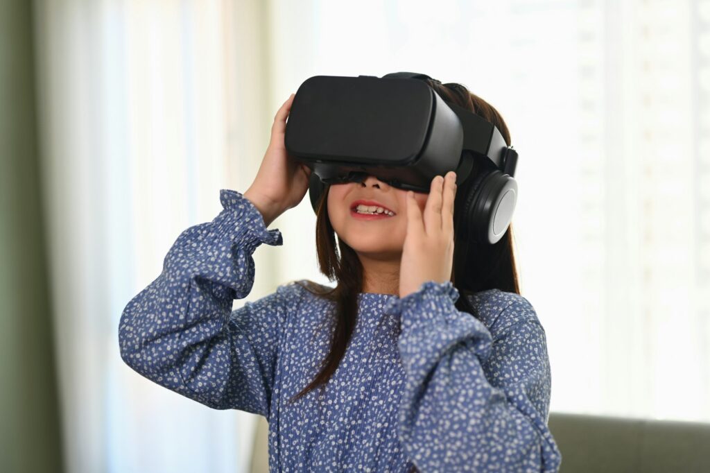 Happy schoolgirl using VR glasses for education learning. Future education technology concept.