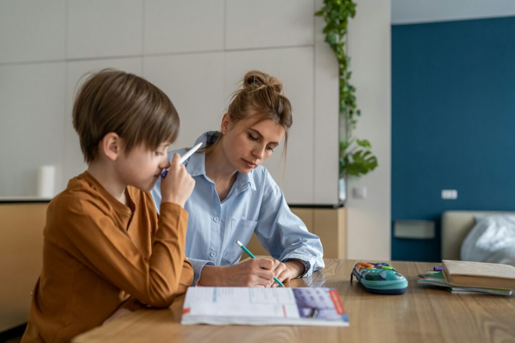 Schoolboy having lesson with private teacher at home